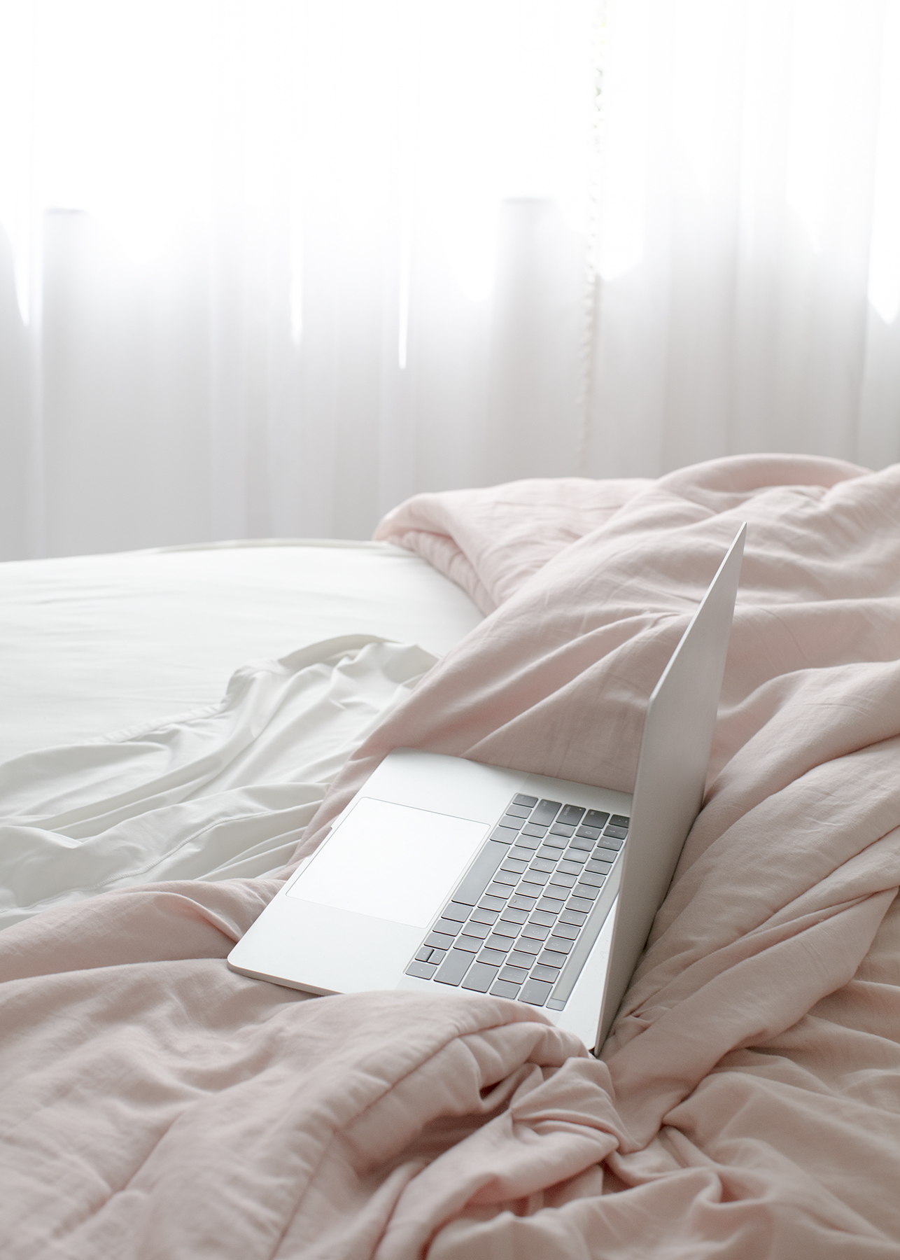 laptop open on bed